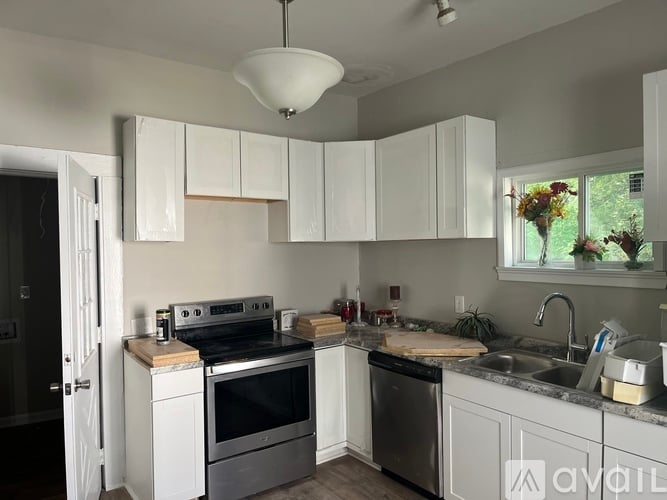 A kitchen with white cabinets and a black stove top oven.