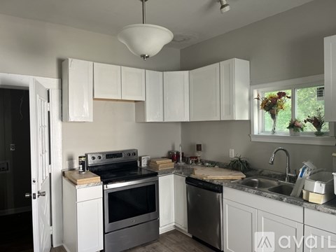 A kitchen with white cabinets and a black stove top oven.