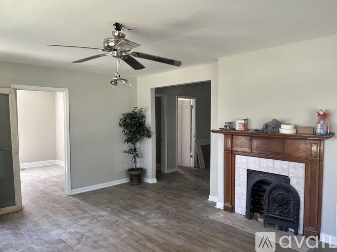 A room with a fireplace and a ceiling fan.