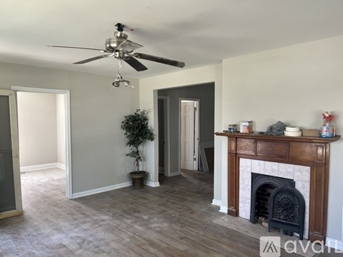A room with a fireplace and a ceiling fan.