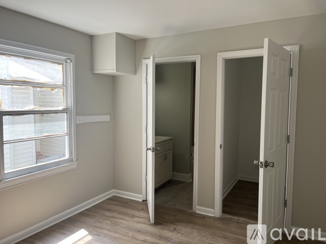 A room with a window, a door, and a cabinet.