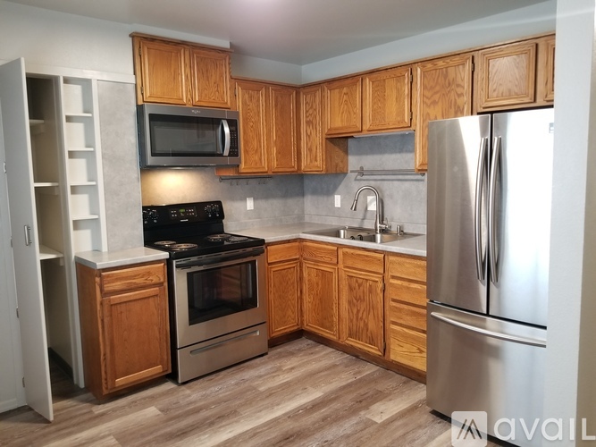 A kitchen with wooden cabinets and a stainless steel refrigerator.