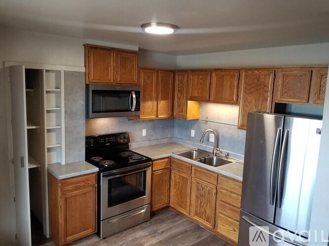 A kitchen with wooden cabinets and stainless steel appliances.