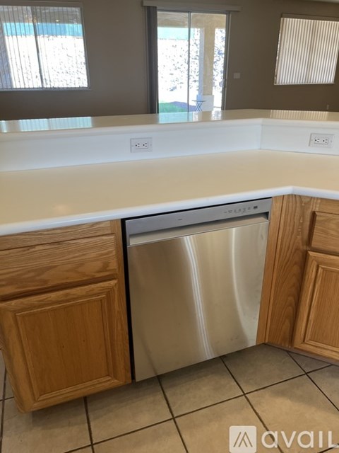 A kitchen with a dishwasher and wooden cabinets.