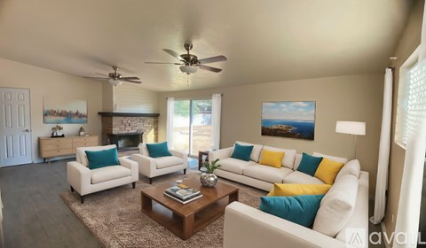 A living room with a white couch, a coffee table, and a painting on the wall.