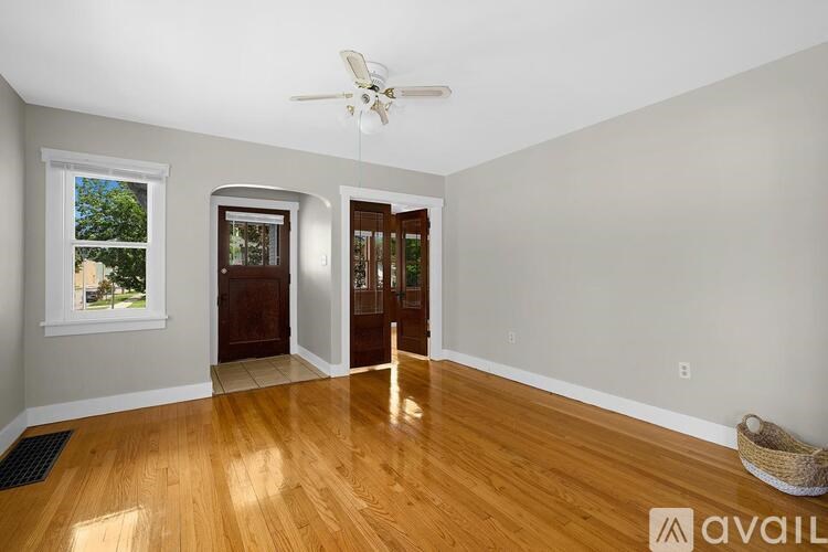 A room with a wooden floor and a ceiling fan.