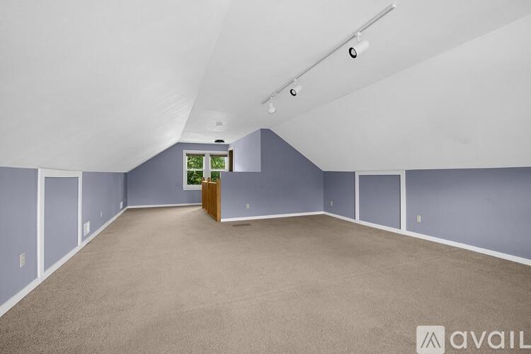 A spacious room with a carpeted floor and a wooden cabinet in the corner.