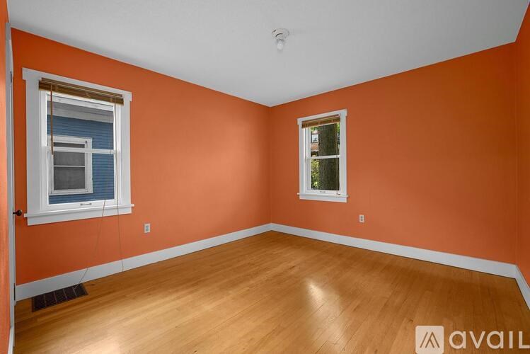 A room with orange walls and wooden flooring.