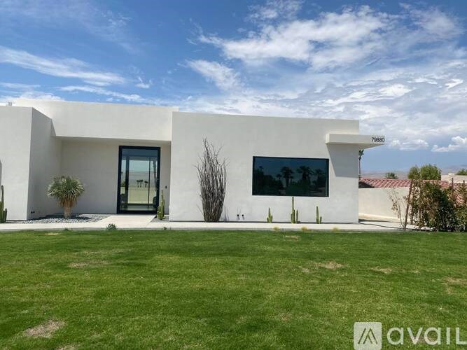 A modern white house with a glass door and windows.