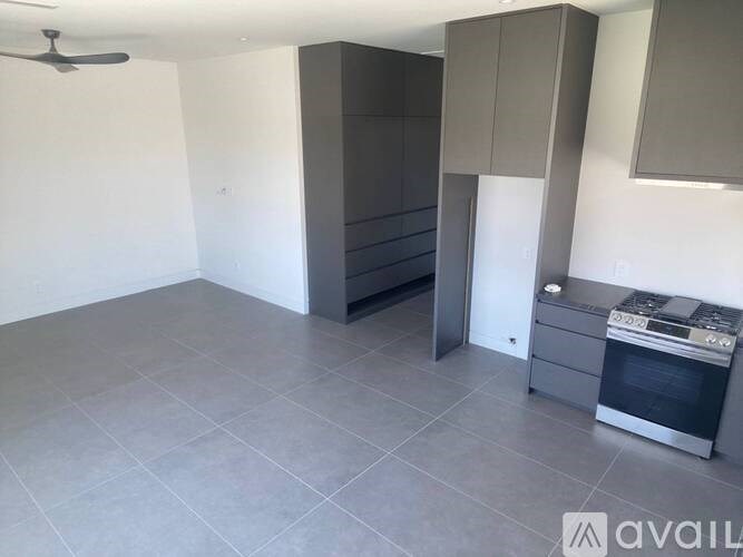 A kitchen with grey cabinets and a stove top oven.