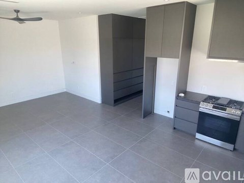 A kitchen with grey cabinets and a stove top oven.