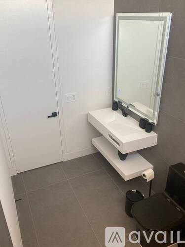 A bathroom with a toilet, sink, and mirror.