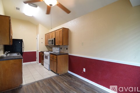 A kitchen with a refrigerator, microwave, and oven.