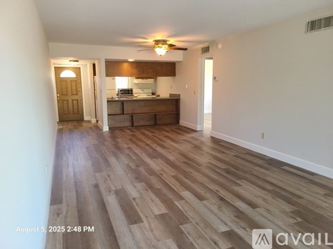 A room with wooden flooring and a ceiling fan.
