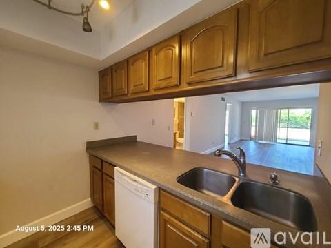 A kitchen with wooden cabinets and a white dishwasher.