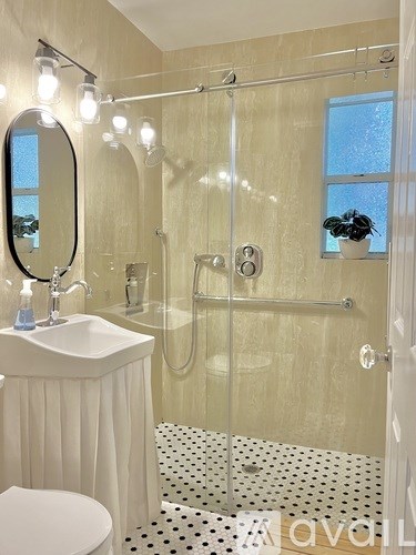 A bathroom with a white sink and a shower with a glass door.