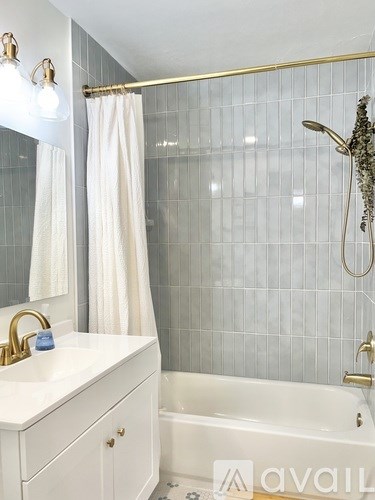 A bathroom with a white sink and a white bathtub.