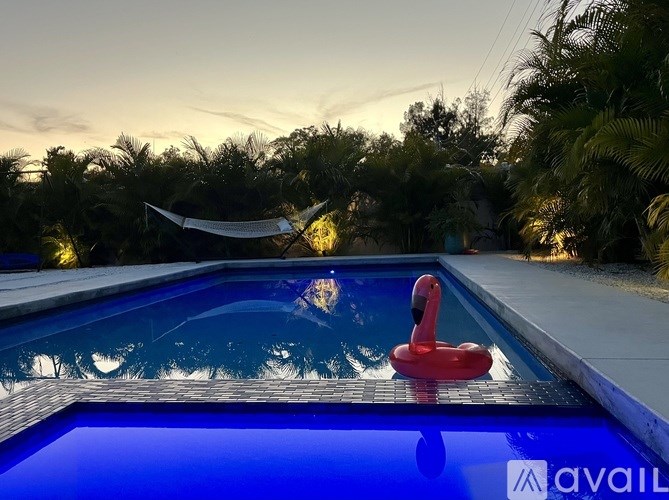 A pool with a red flamingo float in the middle of it.
