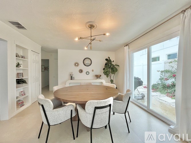 A dining room with a round table and chairs.