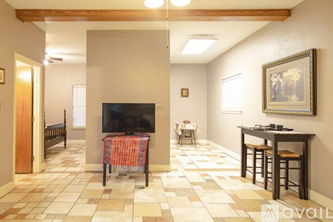 A living room with a television and a table with chairs.