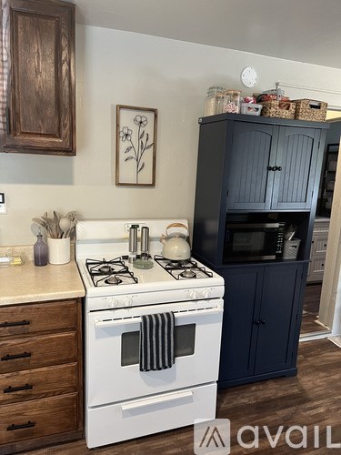A kitchen with a white stove top and a white oven, a white counter top and a white wall.