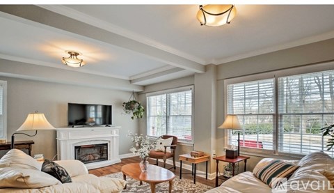 A living room with a fireplace and a television on the wall.