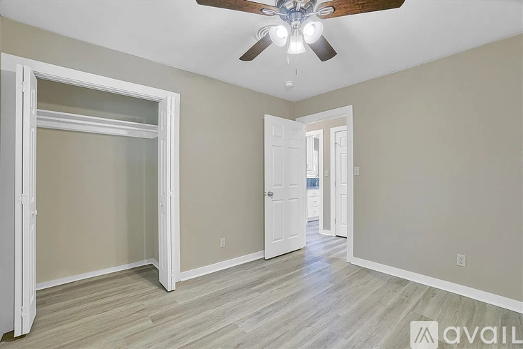 A room with a ceiling fan and a doorway leading to another room.
