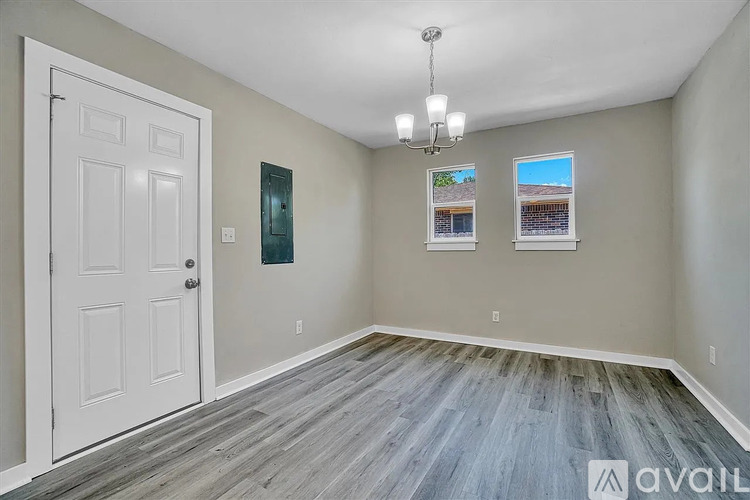 A room with a white door and a chandelier.