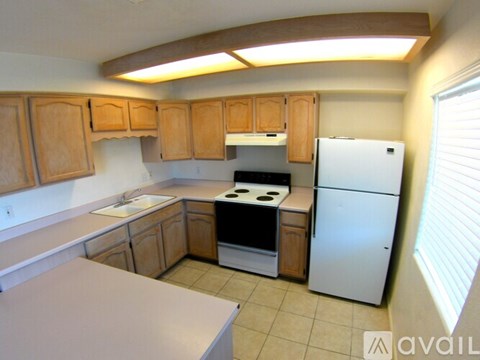 A kitchen with wooden cabinets and a white refrigerator.