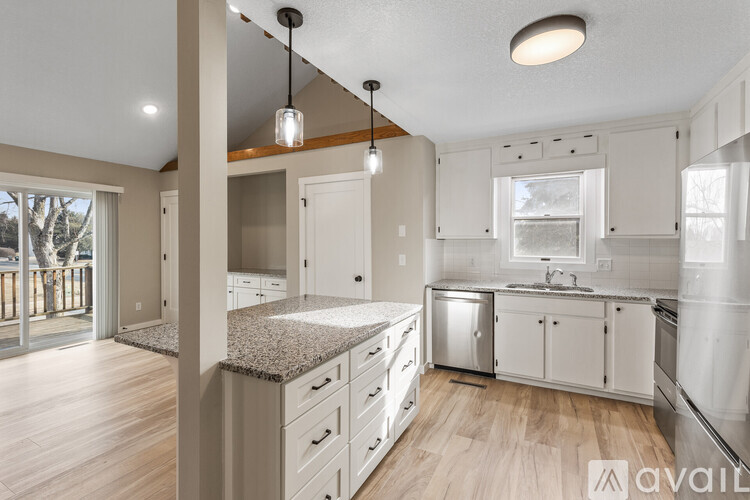 A kitchen with white cabinets and a granite countertop.