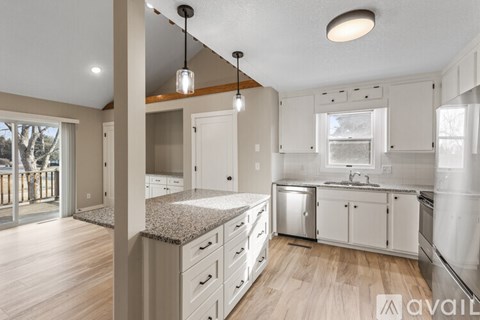 A kitchen with white cabinets and a granite countertop.