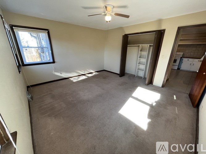 A room with a ceiling fan and a window.