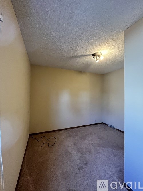 A room with a concrete floor and a wall with a light switch.