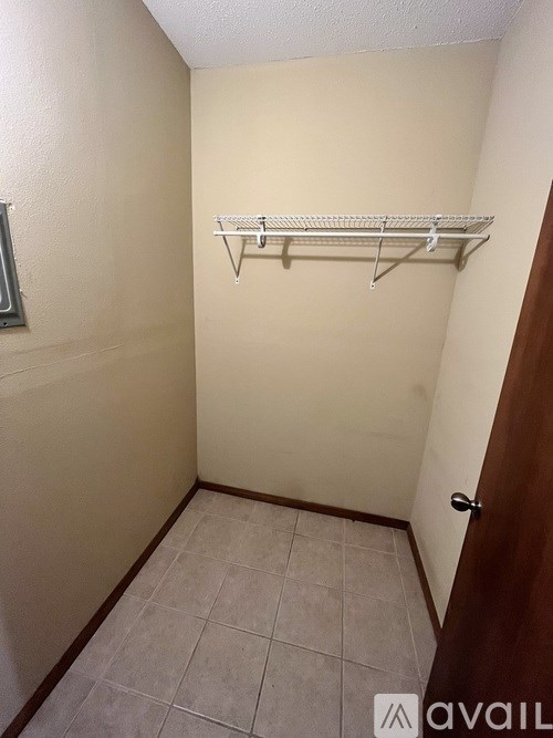 A small, empty room with a shelf and a door.