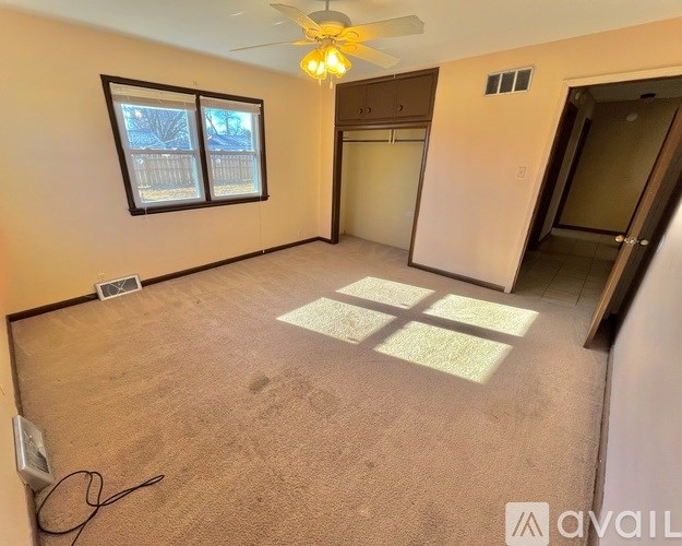A room with a ceiling fan and a window.