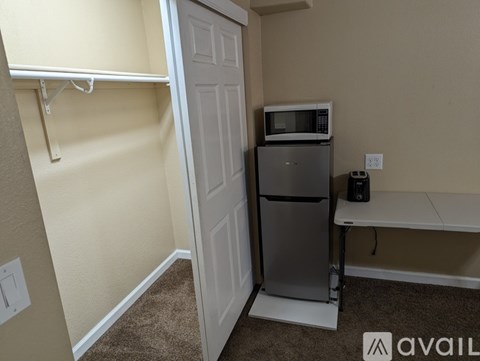 A small kitchen with a white fridge and microwave.