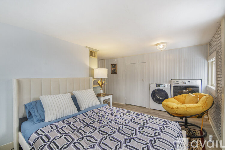 A bedroom with a large bed and a yellow chair.