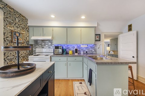 A kitchen with a white counter top and a wooden floor.