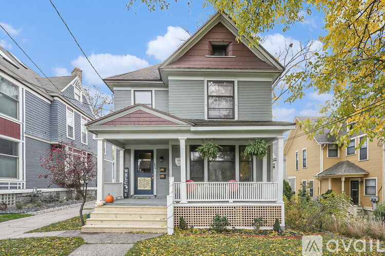 A house with a front porch and a front yard with a tree.