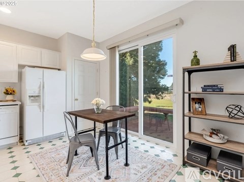A kitchen with a table and chairs in front of a window.