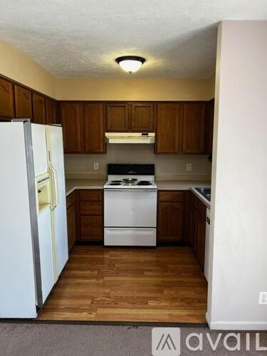 A kitchen with a white refrigerator and a white stove top oven.