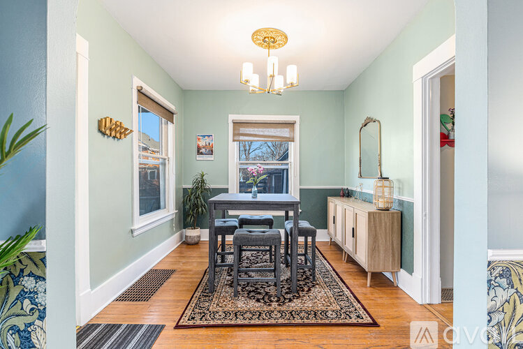 A dining room with a table and chairs.