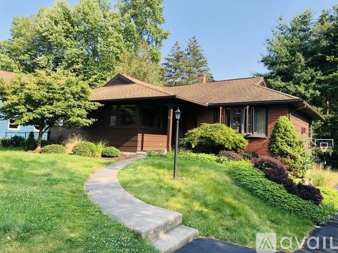 A house with a brown roof and a green lawn.