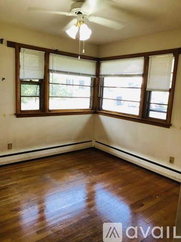 A room with wooden floors and a ceiling fan.