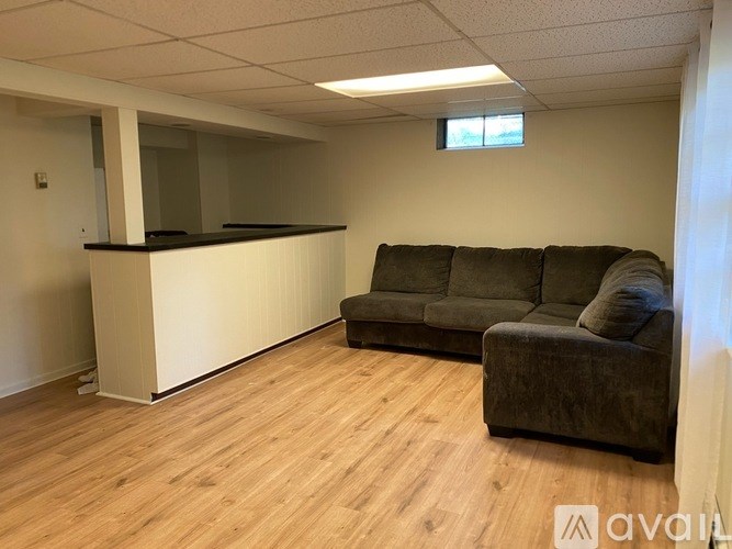 A living room with a grey couch and a wooden floor.