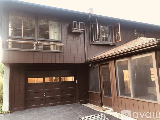 A brown house with a garage door and windows.