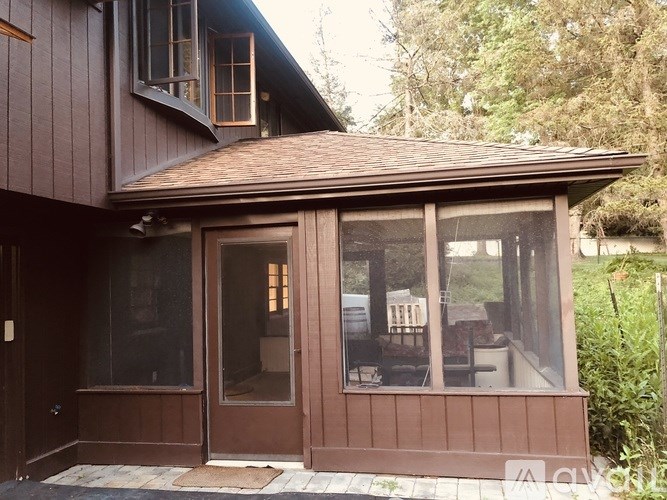 A house with a brown wooden exterior and a brown tiled roof.