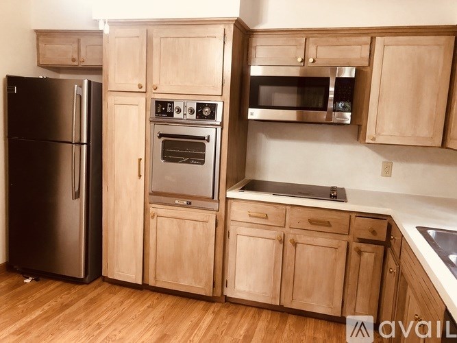 A kitchen with wooden cabinets and stainless steel appliances.
