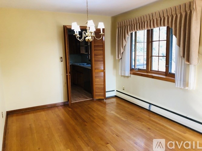 A room with wooden floors and a chandelier.