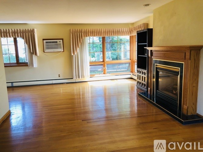 A living room with a fireplace and a large window.